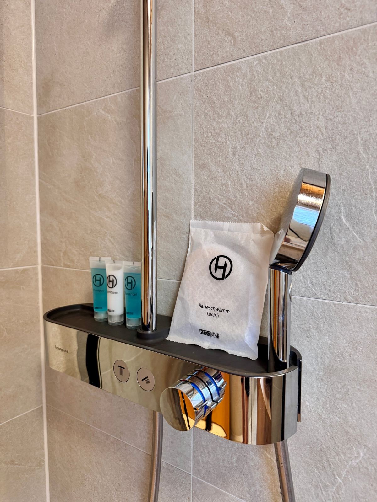 Dusche mit Hansgrohe-Armatur und Pflegeprodukten