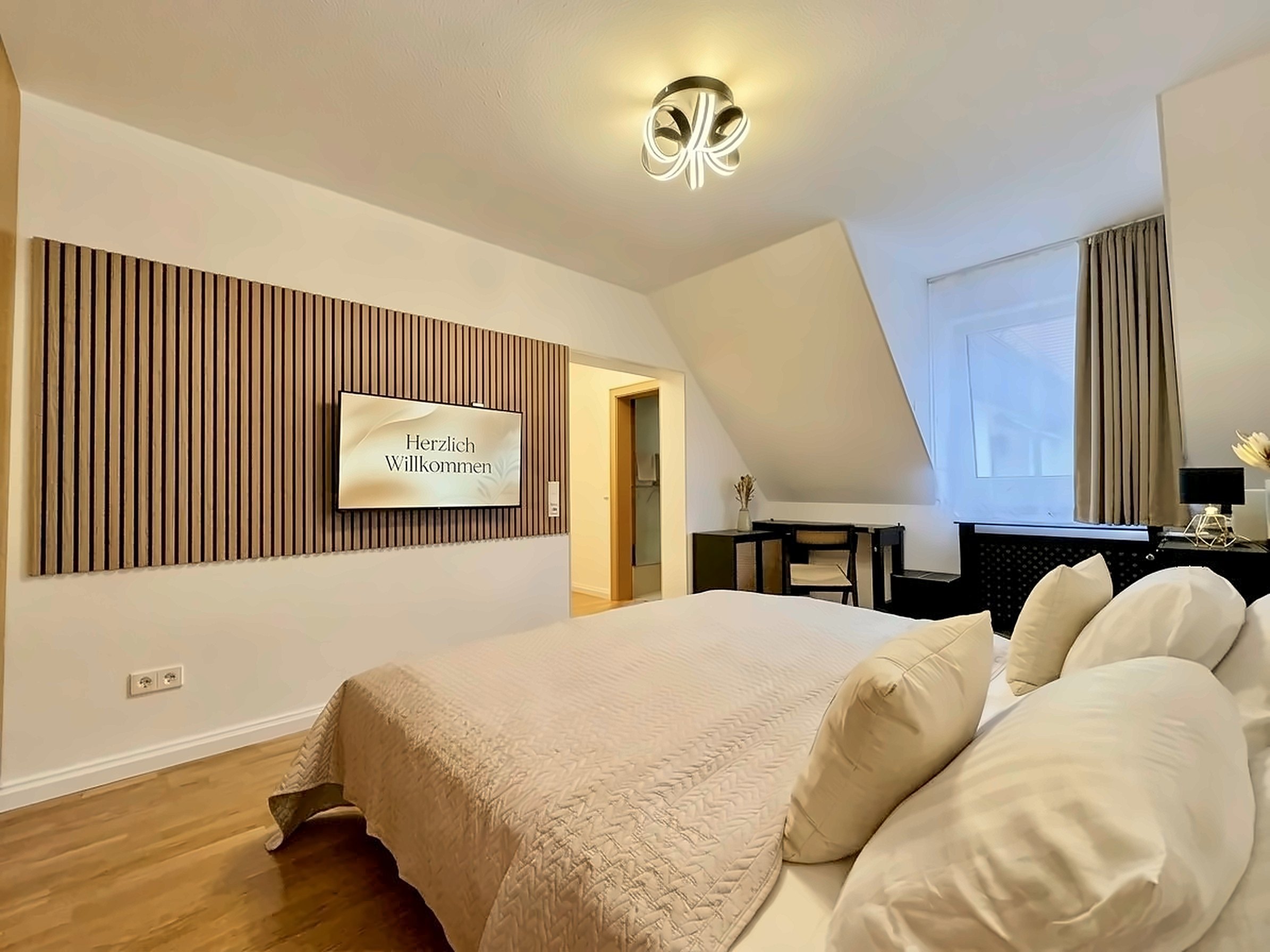 Studio Zur Perle in Bad Krozingen mit King-Size-Bett und Smart-TV an der Holzlattenwand